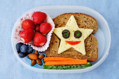 school lunch box for kids with food in the form of funny faces. the toning. selective focus